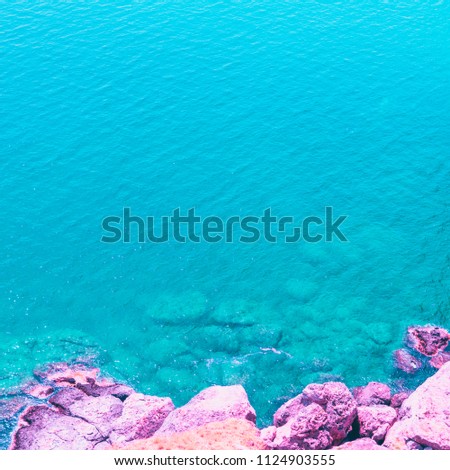 alien sea landscape with pink stones. bright neon colors. minimal and surreal. summer vacation.