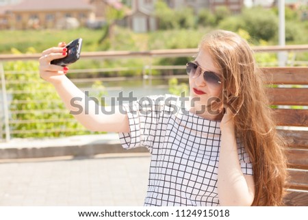Beautiful urban woman taking picture of herself, selfie. Filtered image.
