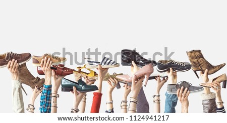 Hands holding different shoes on isolated background Royalty-Free Stock Photo #1124941217