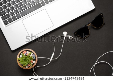 Notebook and white earphone on black background. Design and Inte