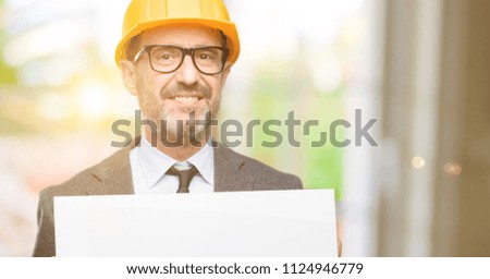 Senior architect or engineer holding blank advertising banner, good poster for ad, offer or announcement, big paper billboard