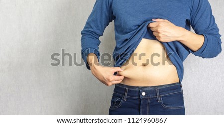 Belly fat pulled by man hand Royalty-Free Stock Photo #1124960867