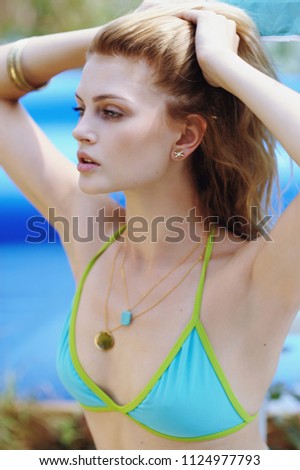 Blond girl in swimsuit on hot summer day