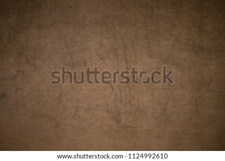 Close-up shot of scratched brown wallpaper.