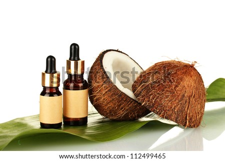 coconut oil in bottles with coconuts on white background