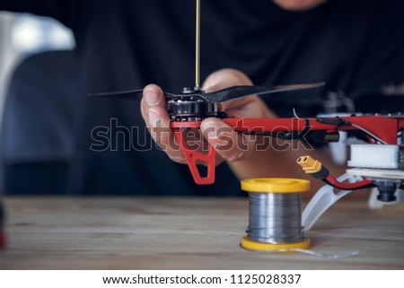 Photo of man with screwdriver cleaning drone