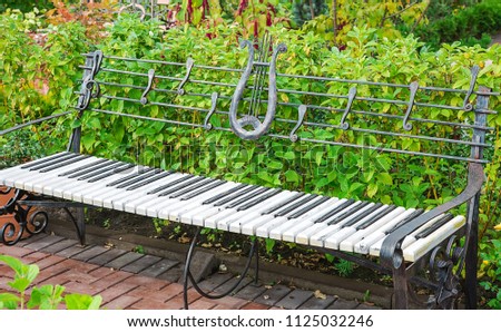 Photo of a bench in the form of a musical instrument of a piano in the park
