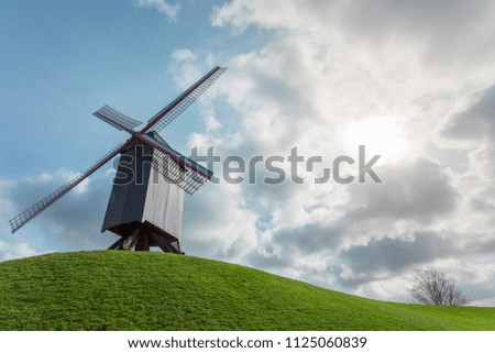Landscape photography of windmill at green grass field with dramatic sky background
