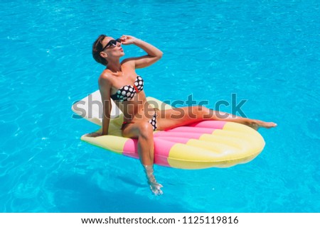 Woman lying on water matrass in the pool