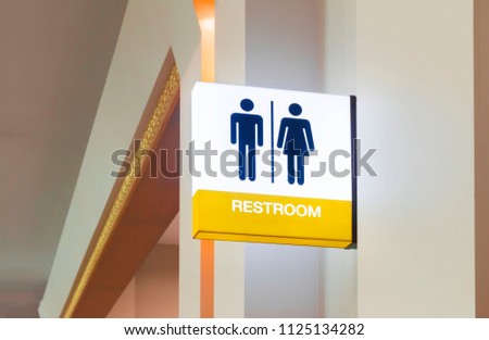 Restroom sign or toilet sign made of electric light box with man and woman icon set  symbol on white concrete wall background, modern, hygiene and clean restroom concept
