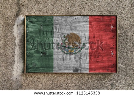 
Wooden nameplate on the wall with a painted flag of Mexico on it