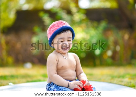 Cute indian baby boy playing at garden