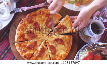 Top view of cut of slice of Pizza with salami from the wooden board