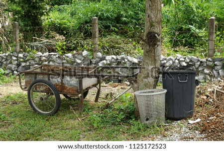   Old cart with plastic bin in the garden                             