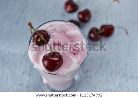 creamy and cherry ice cream in a glass bowl with fresh cherries