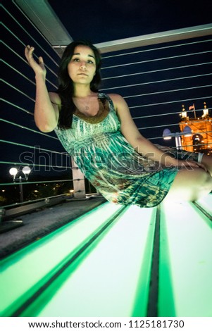 Latina Model on Green LED Platform in front of Reobling Bridge to Kentucky