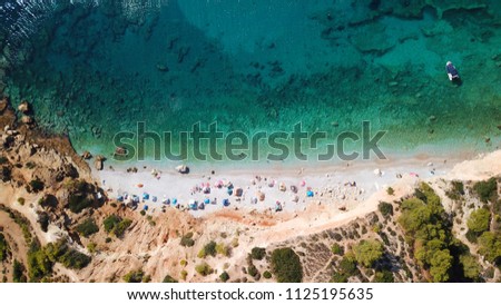 Aerial drone bird's eye panoramic view of iconic rocky beach of Halikiada with turquoise and sapphire sea, Agistri island, Saronic gulf, Greece
