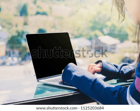 business with outdoor travel concept from beauty woman hand use laptop and put on counter of coffee bar with soft focus forest and mountain background