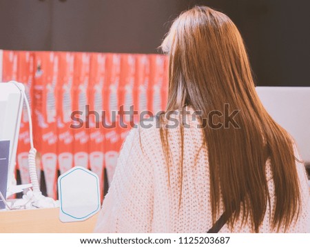 woman travel in city concept from back side of long hair asian woman during pay and shopping at payment counter with soft focus background
