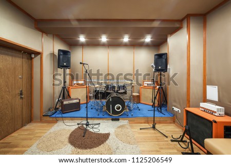 Music rehearsal space with drum kit and musical equipment. Royalty-Free Stock Photo #1125206549