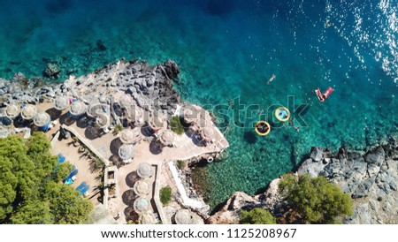Aerial drone bird's eye top view of people sitting in inflatable matress and pool in rocky emerlad water tropical caribbean resort
