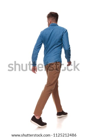 rear view of casual man walking and looking to side on white background, full length picture
