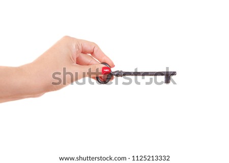 A female hand holds a large old key. Isolated on white background.