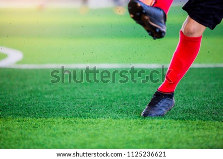 Blurry picture of The soccer player after shoot ball on artificial turf.