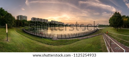 Panoramic view of Bedok Reservoir, Singapore during sunset hours. Photographed as composite images to form HDR Panorama in final image. Royalty-Free Stock Photo #1125254933
