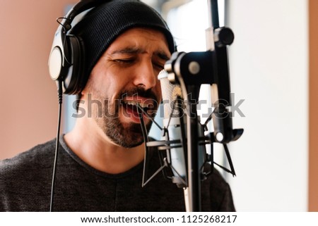Young man singing on musical studio.
