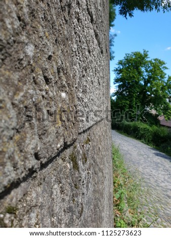 wall with natural limestone on a background with trees and blue sky 