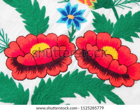 Ukrainian folk embroidery, embroidered red flowers isolated on white fabric, fabric decor, hand embroidery