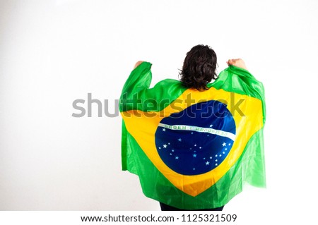 Cheering for Brazil with green and yellow flag, white background. Space for your text. Royalty-Free Stock Photo #1125321509