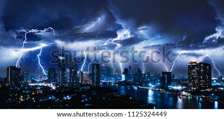 Lightning storm over city in blue light Royalty-Free Stock Photo #1125324449
