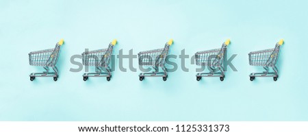 Shopping cart on blue background. Minimalism style. Creative design. Top view with copy space. Shop trolley at supermarket. Sale, discount, shopaholism concept. Consumer society trend. Royalty-Free Stock Photo #1125331373