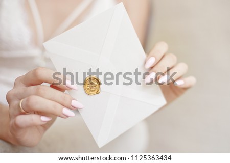 close-up woman with slim body holding invitation envelope card in hands, rear veaw.