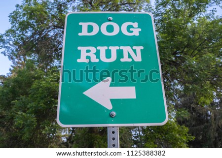 Dog Run Sign At A Pet Park Near A Walking Trail Royalty-Free Stock Photo #1125388382