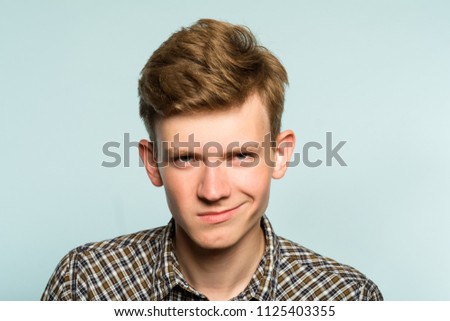 smug smile. man with a self satisfied smirk. portrait of a young guy on light background. emotion facial expression. feelings and people reaction. Royalty-Free Stock Photo #1125403355