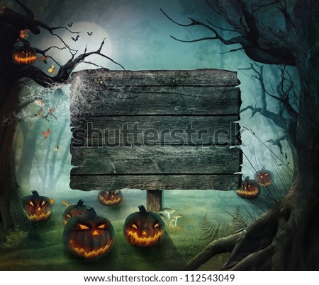 Halloween design - Forest pumpkins. Horror background with autumn valley with woods, spooky tree, pumpkins and spider web. Space for your Halloween holiday text. Royalty-Free Stock Photo #112543049