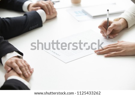 Businesswoman signing business document at group meeting, client customer puts signature on contract agreement buying services, taking bank loan, making legal partnership deal concept, close up view Royalty-Free Stock Photo #1125433262
