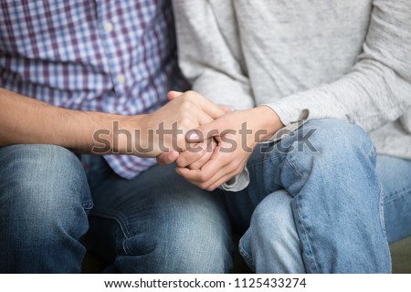 Support in marriage concept, close up view of couple holding hands expressing sympathy and hope, overcoming problems together, fertility treatment, reconciliation and understanding in relationships Royalty-Free Stock Photo #1125433274