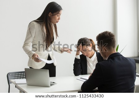 Angry asian executive shouting at subordinates scolding for bad results in report at diverse meeting, mad chinese female ceo boss leader dissatisfied with team incompetence reprimanding employees Royalty-Free Stock Photo #1125433430
