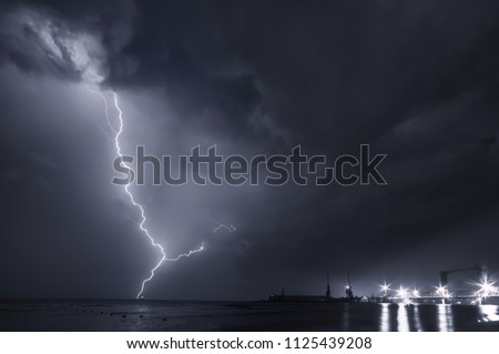 Summer storm, dramatic sky  and amazing lightnings over the ocean. natural background. black and white toned picture