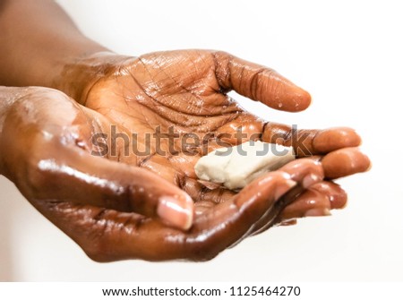 Acupressure, hand massage. Black woman in the spa salon for a massage hand. Brown skin woman applying natural Shea butter scrub on hands isolated on white background