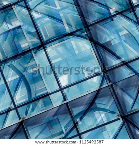 Glass wall reflecting blue sky. Multiple exposure photo of office building fragment. Abstract image on the subject of modern architecture, real estate or construction industry. Glass background.