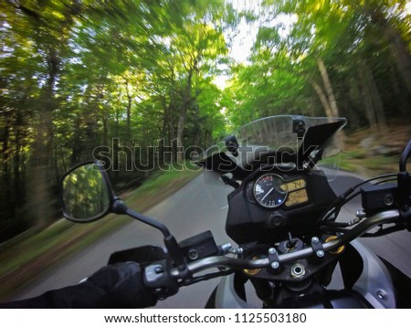 Motorcycle driving taking fast curve on road