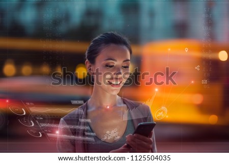 Staying up to date with technology in a fast moving world, concept. A young asian woman is using an innovative future technology to view her phone data and functions in holographic display around her Royalty-Free Stock Photo #1125504035