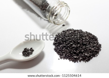 activated carbon or granular in clear bottle is used in air purification, decaffeinate, gold purification, metal extraction, water purification, medicine, sewage treatment, air filters in gas masks Royalty-Free Stock Photo #1125504614