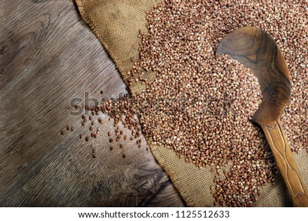 Buckwheat seeds on wooden spoon. close up. top view.
