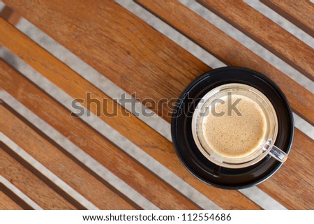 Coffee in a Black Ceramic Cup on a Wooden Table